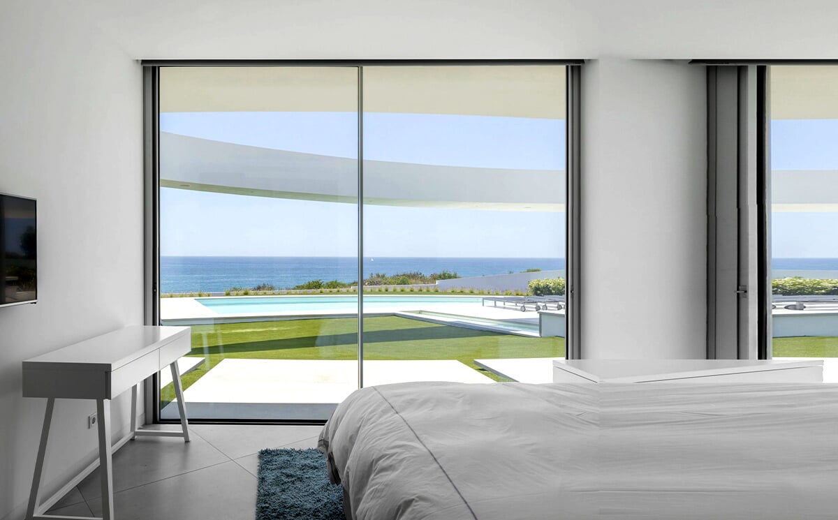 Panoramic Living Room Facing Outdoor Greenery Through Large Glass Wall