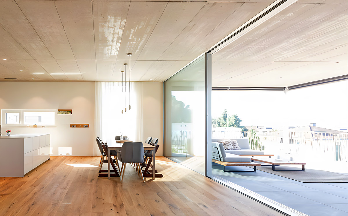 Flush track minimal frame sliding door seamlessly connecting indoor living room and outdoor patio