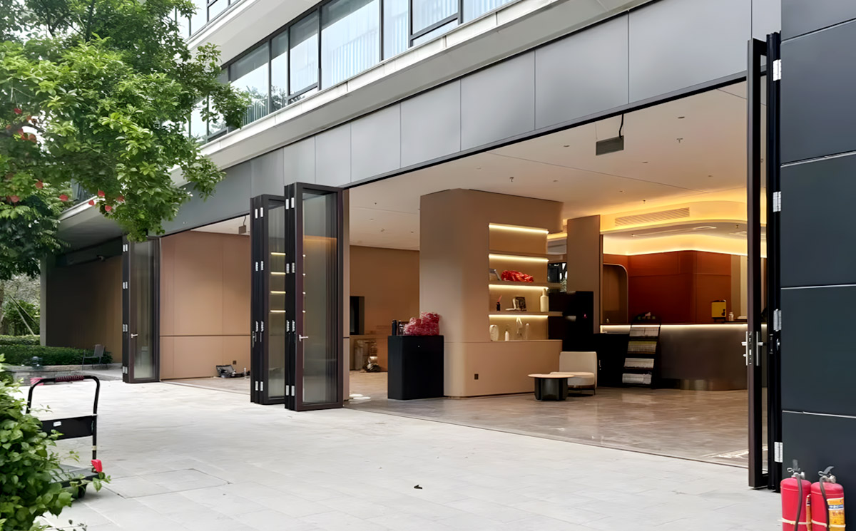 Heavy-duty, multi-panel aluminum folding glass doors creating a massive open entrance for a commercial luxury space