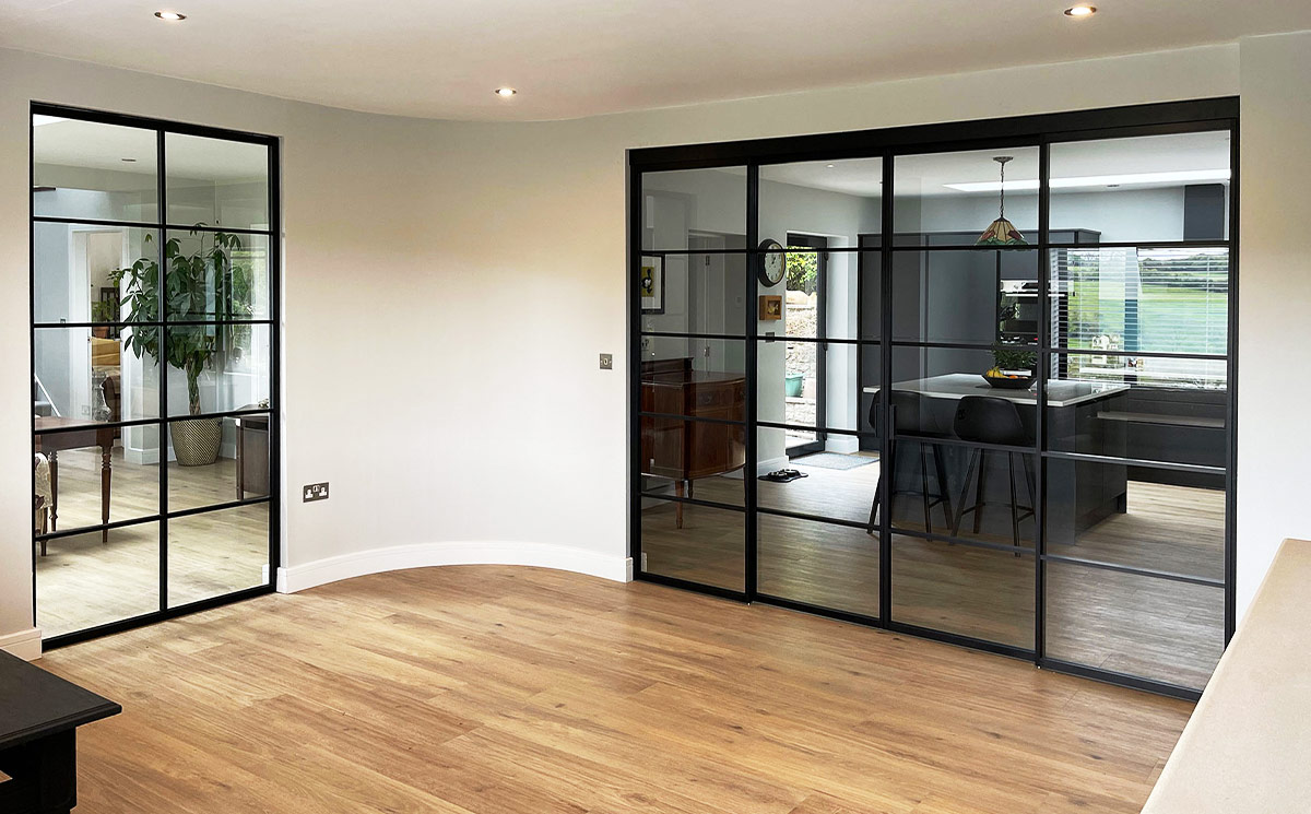 Steel-look French doors double configuration with thin black grid frames used as an interior glass wall divider