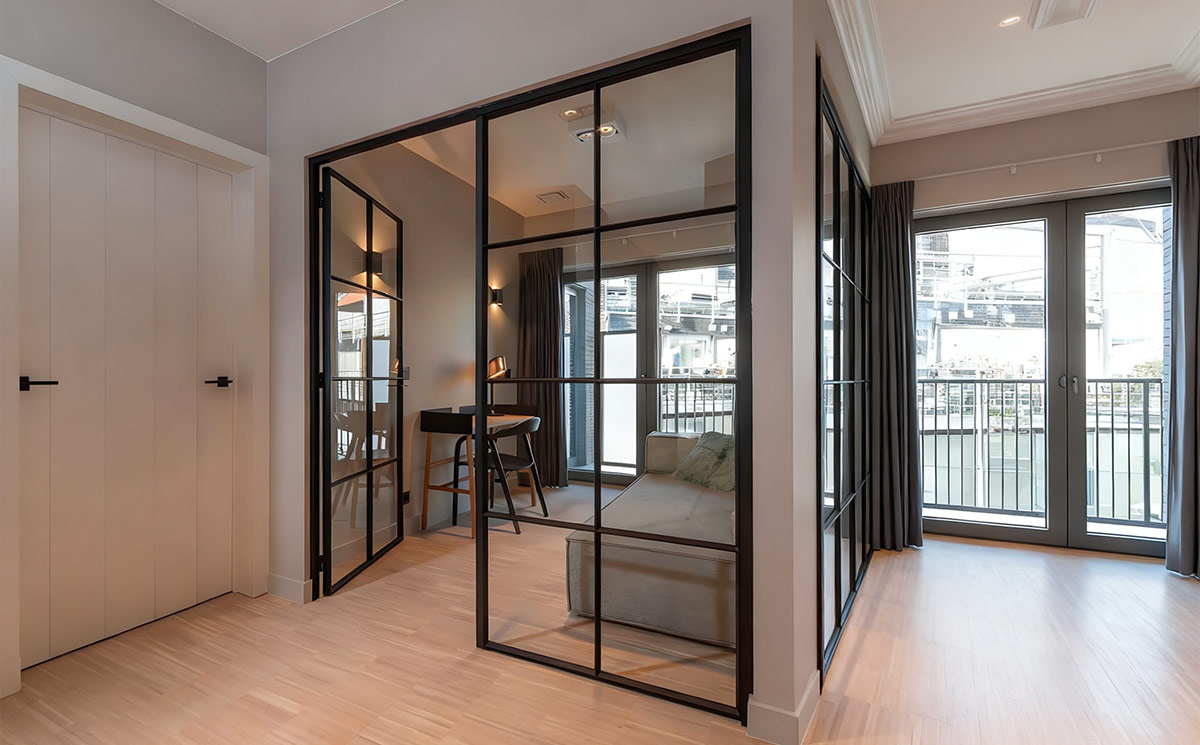 Minimalist glass office partition doors creating a modern L-shaped glass enclose for a private home workspace