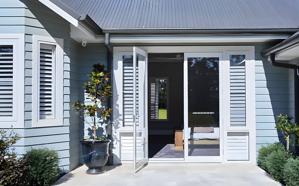 White aluminum exterior French doors with integrated louvered privacy sidelites for patio